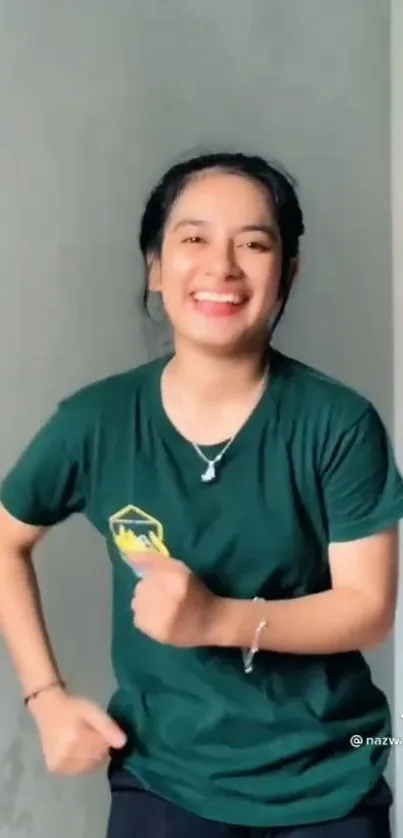 Smiling woman in green shirt posing indoors.