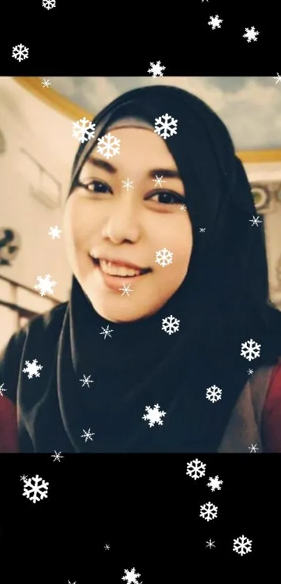 Smiling woman wearing a black hijab in soft lighting.