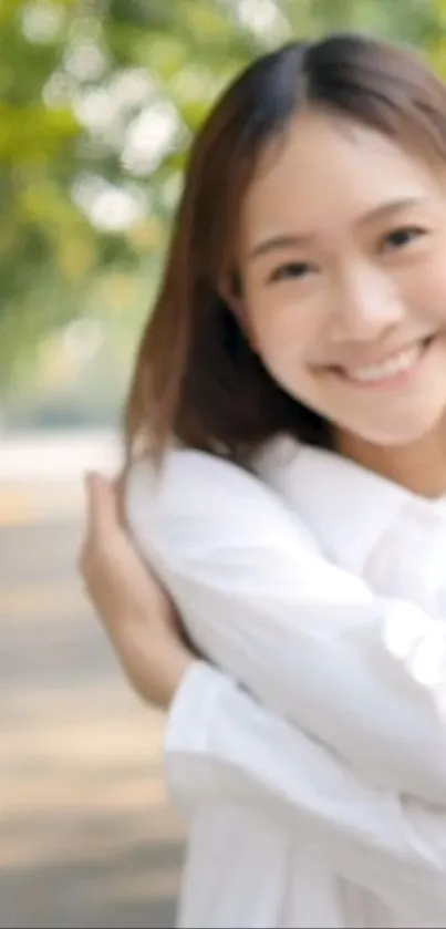 Smiling woman wearing white in nature setting.