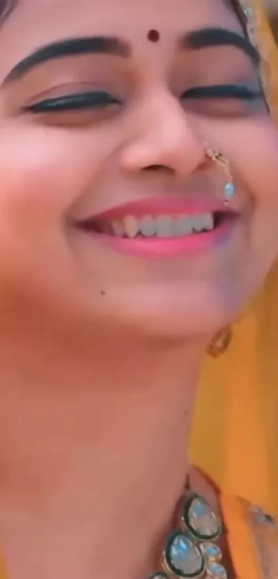 A woman smiling in yellow traditional attire, with jewelry and vibrant expression.