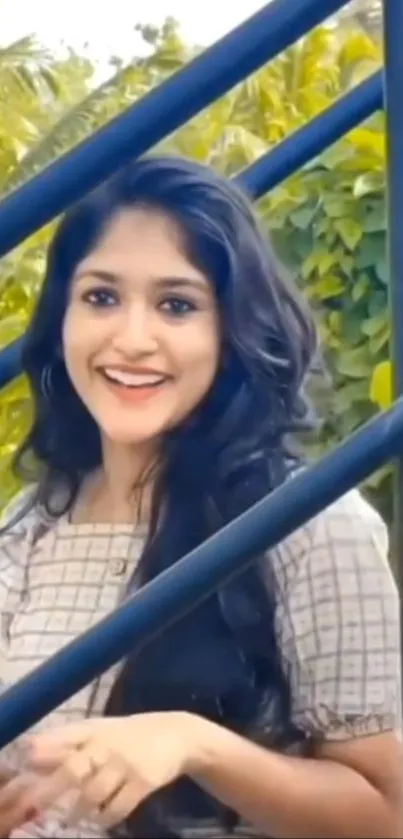 Smiling woman on stairs with background greenery.