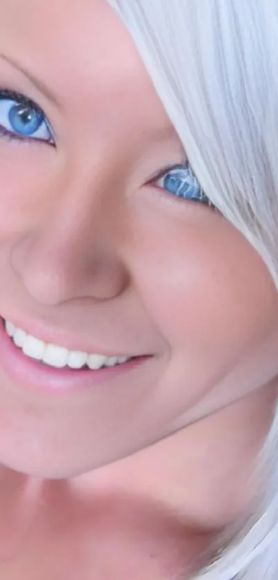 Portrait of a smiling woman with blue eyes and platinum hair.