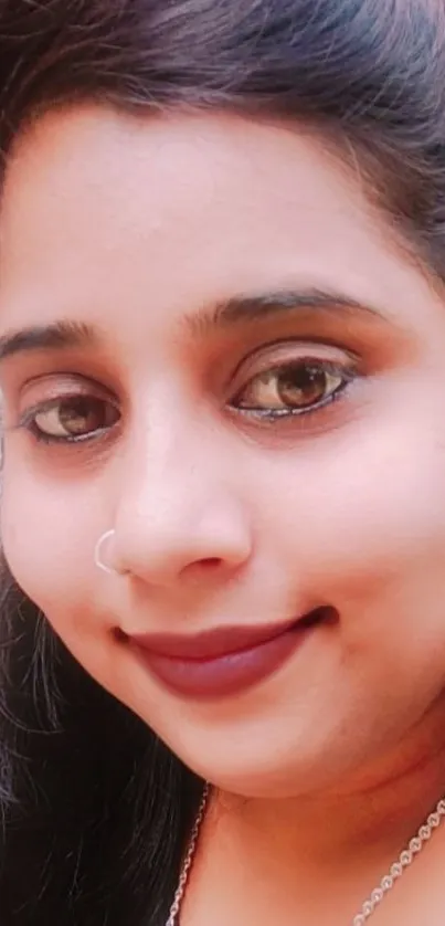 Portrait of a smiling woman with dark hair and expressive eyes.