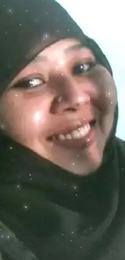 Woman in black hijab smiles with sparkling effect background.