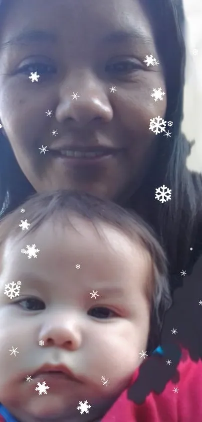 Mother and baby with snowflake overlay on mobile wallpaper.