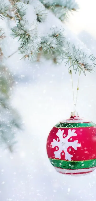 Red Christmas ornament on snowy branch wallpaper.