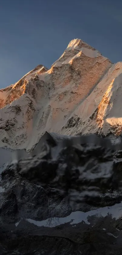 Majestic snowy mountain during sunset with golden hues and serene landscape.