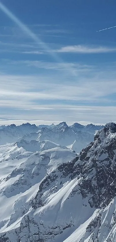 Snowy mountain range with blue sky and clouds.