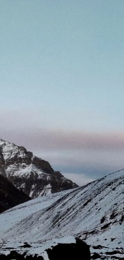 Snowy mountain landscape with rugged peaks and a serene sky.