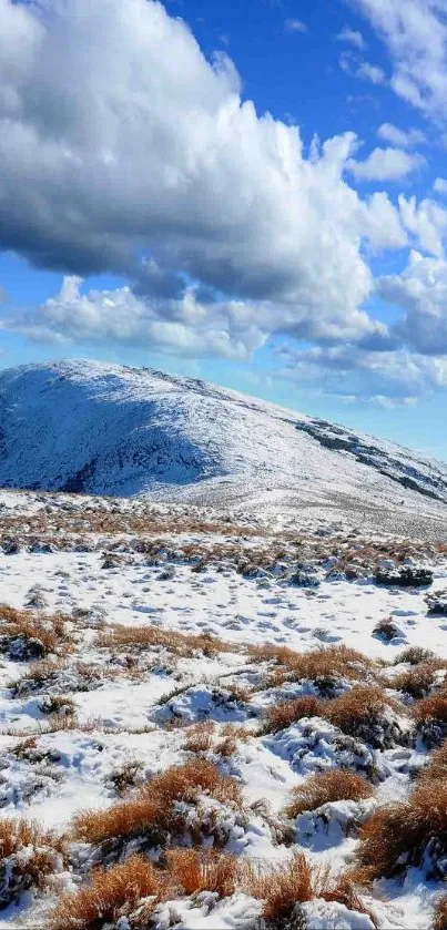 Snowy mountain landscape with blue sky and clouds.
