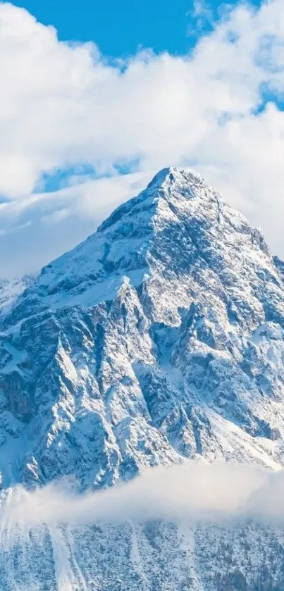 Snowy mountain peak with blue skies and clouds in a serene landscape.