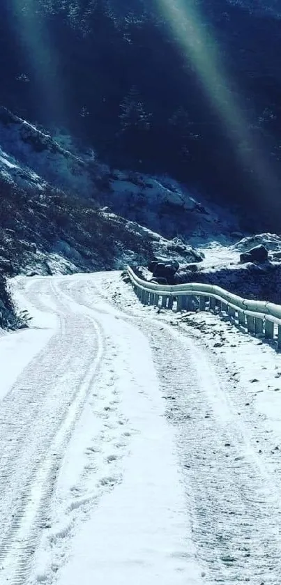 Snow-covered mountain road under clear sky.