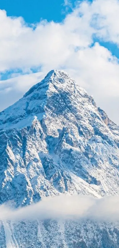 Snow-covered mountain peak with blue sky and clouds above.