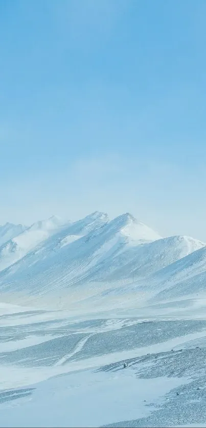 Serene snowy mountain landscape with blue sky.