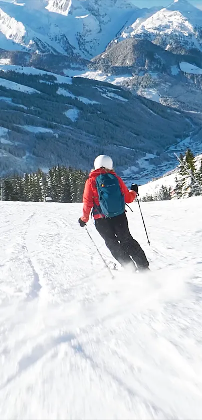 Skier descends snowy mountains under blue skies.