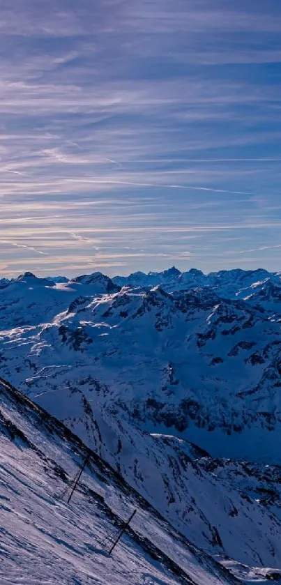 Snowy mountain landscape with sunrise and blue sky.