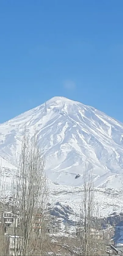 Snowy village with mountain and blue sky background.