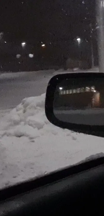 Snowy night scene viewed through a car's side mirror reflecting serene winter landscape.