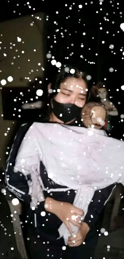 Person holding a child surrounded by snowflakes at night.