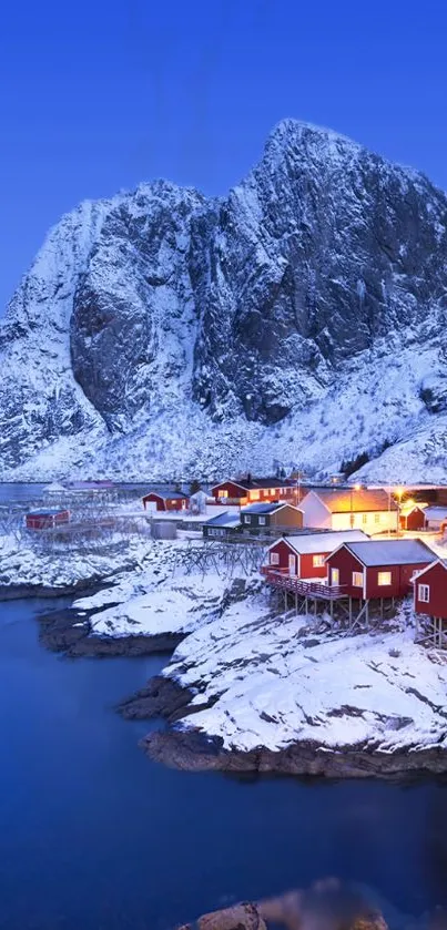 Snowy Scandinavian village at dusk with a mountain backdrop.