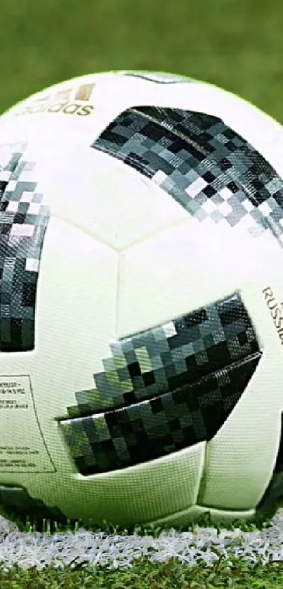 Soccer ball on vibrant green field wallpaper.