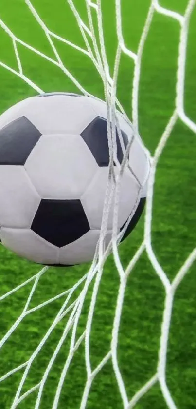 Soccer ball hitting the goal net on a green field.