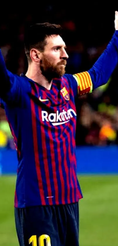 Soccer player raising arms in celebration on the field during a match.