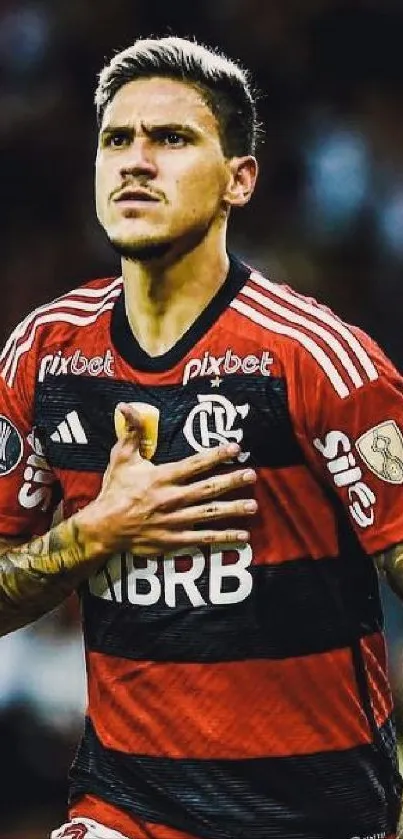 Focused soccer player in red jersey during a match.
