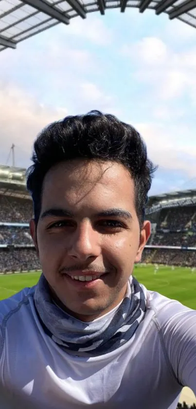 Selfie in a packed soccer stadium with green field backdrop.