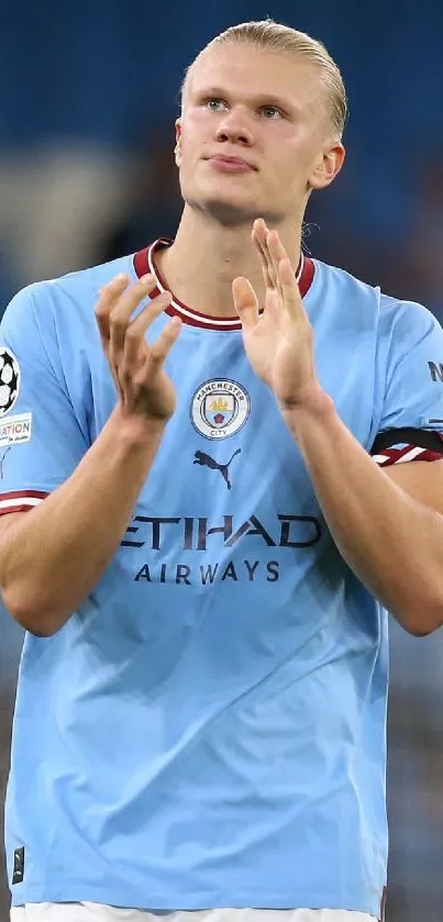 Soccer player applauding in blue jersey at the stadium.