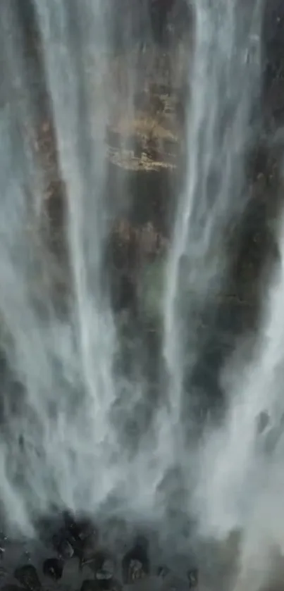 A stunning vertical waterfall cascades down rock cliffs, creating a peaceful scene.