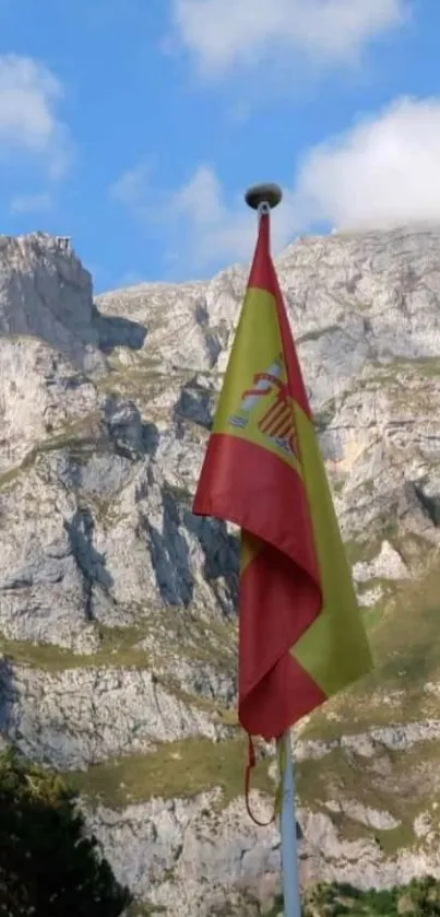 Spanish flag with mountainous backdrop and blue sky.