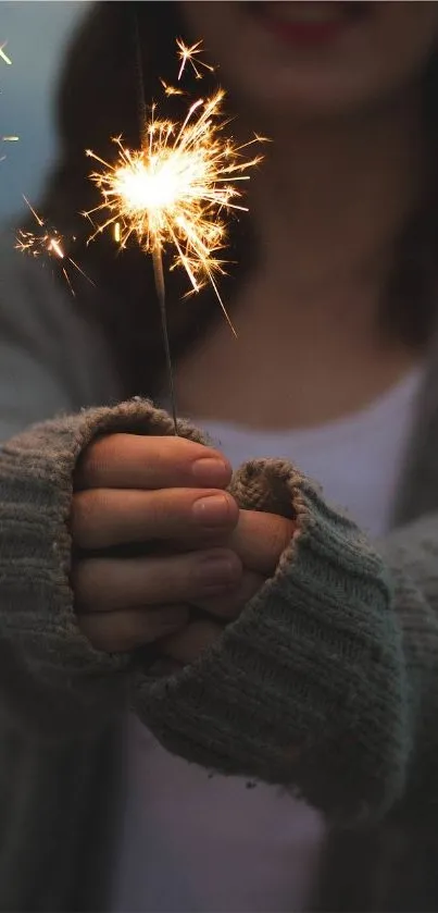 A sparkler illuminating cozy hands in knitted sleeves.