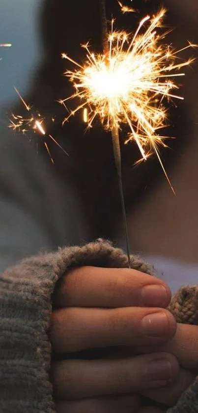 Hands holding a sparkler, glowing warmly in a cozy ambiance.