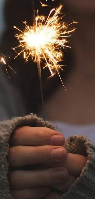 Hands holding a glowing sparkler against a dark background.