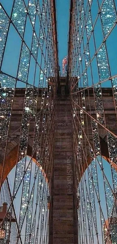 Illuminated bridge at night with sparkling lights and blue sky.