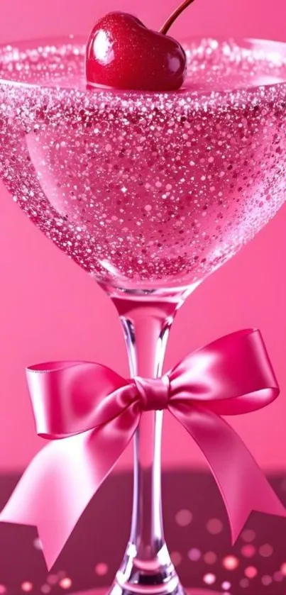 Sparkling cherry cocktail glass with pink ribbon on pink background.