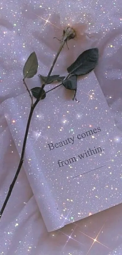 A rose on a sparkling book with the quote 'Beauty comes from within.'