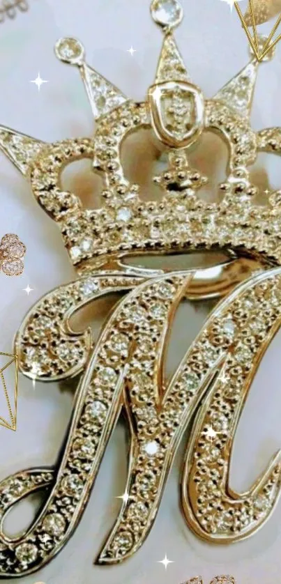 Gold crown with jeweled letter M on luxurious wallpaper.