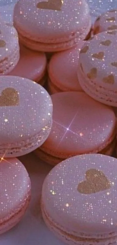 Pink macarons with golden hearts and sparkles on a wallpaper.