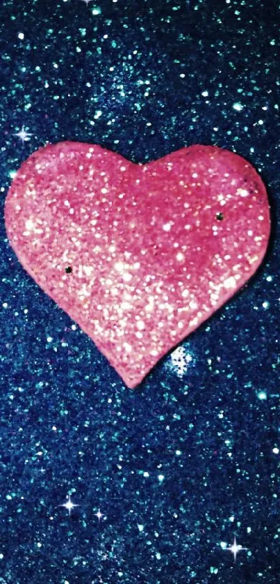 Sparkling pink heart on blue glitter background wallpaper.