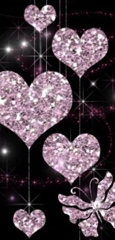 Glittery pink hearts and butterfly on black background.