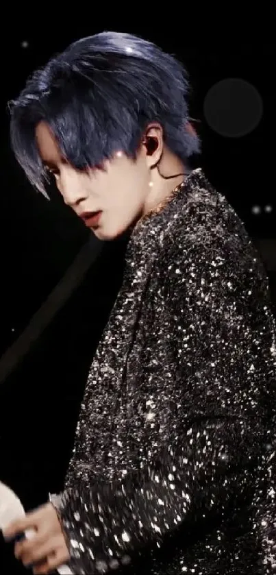 Performer in a sparkling outfit with blue hair on stage.