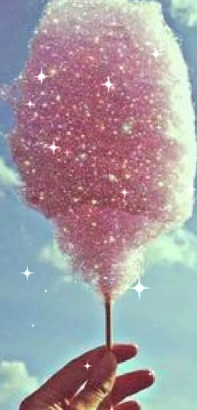 Hand holding sparkling pink cotton candy against a bright blue sky.