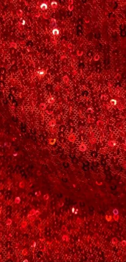 Close-up of red sequin texture sparkling with light reflections.