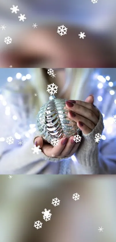 Hands holding a sparkling holiday ornament with snowflakes and festive lights.