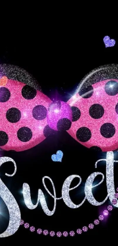 Sparkling sweet bow with pink and polka dots against black background.