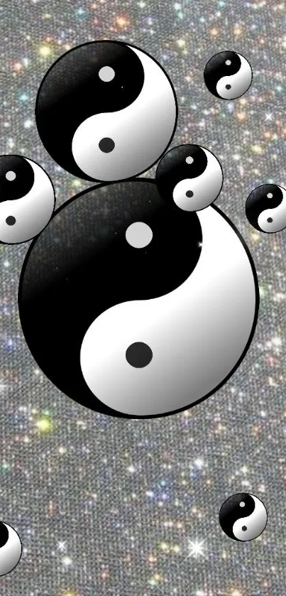 Mobile wallpaper with sparkling Yin Yang symbols on a silver background.