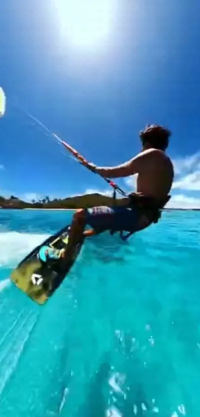 Man kiteboarding over a vibrant blue ocean under a clear sky.