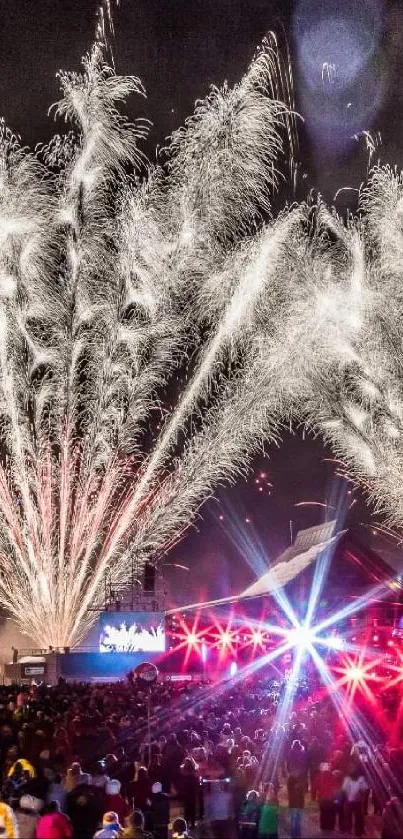 Spectacular fireworks display above a crowded festival at night.